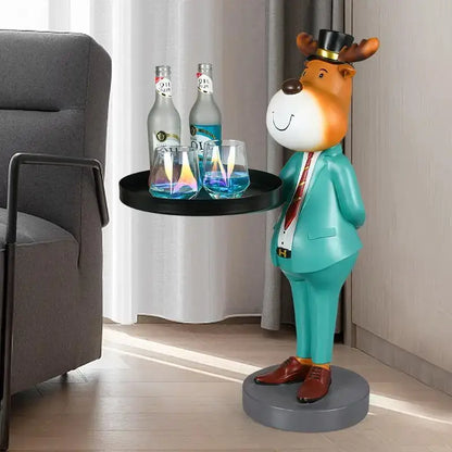 A whimsical deer landing tray ornament in a teal suit holding a black tray with bottles and glasses for decor