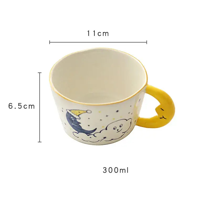 A charming off-white bear moon ceramic mug with a yellow crescent moon handle and a sleeping blue moon design