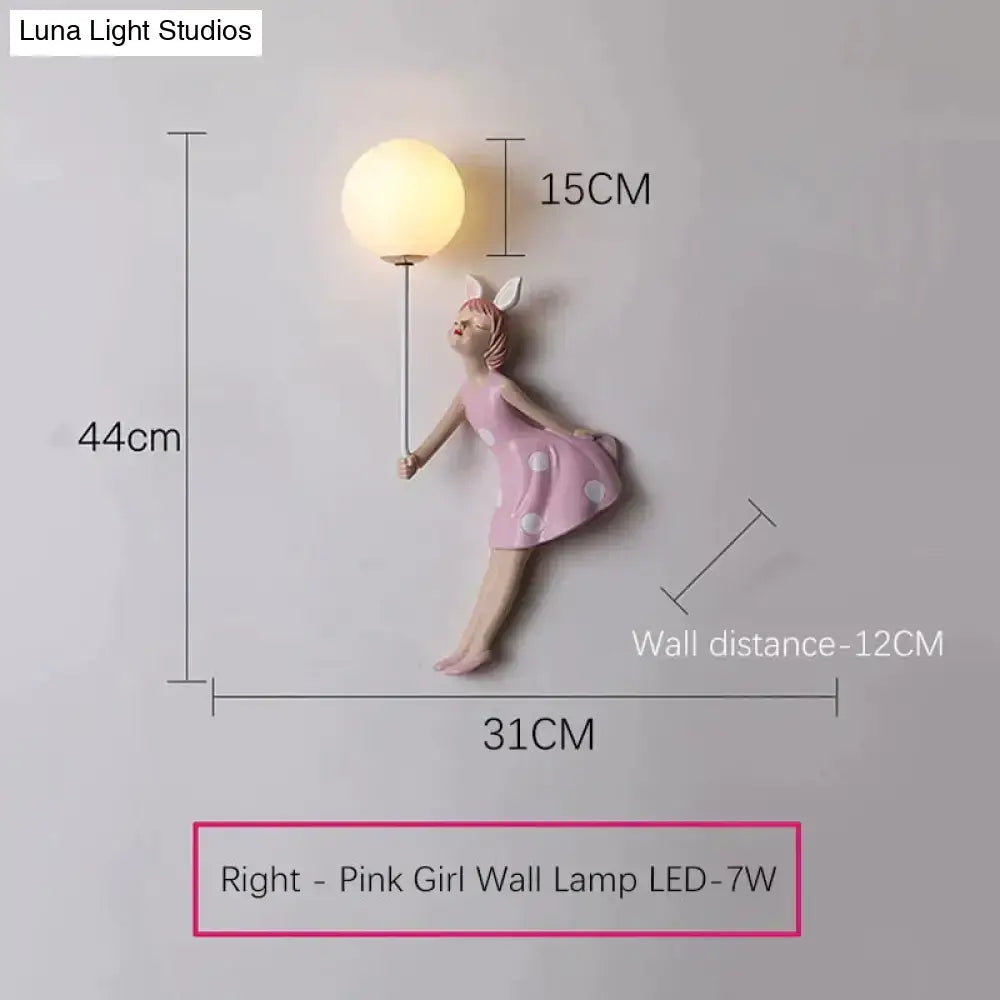 Whimsical pink polka dot girl wall lamp featuring a bunny figurine holding a glowing orb for bedroom use
