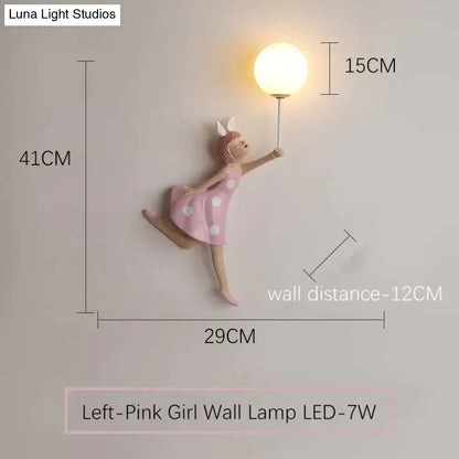 Whimsical pink polka dot girl wall lamp featuring a dancing figure holding an illuminated globe bulb for bedroom use