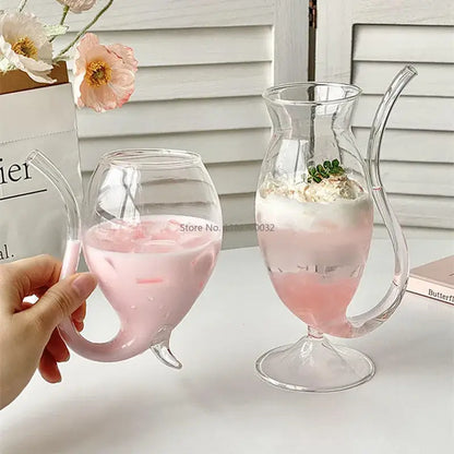 Clear glass vampire cocktail glass cup with curved handle filled with pink liquid and ice for dining room decor