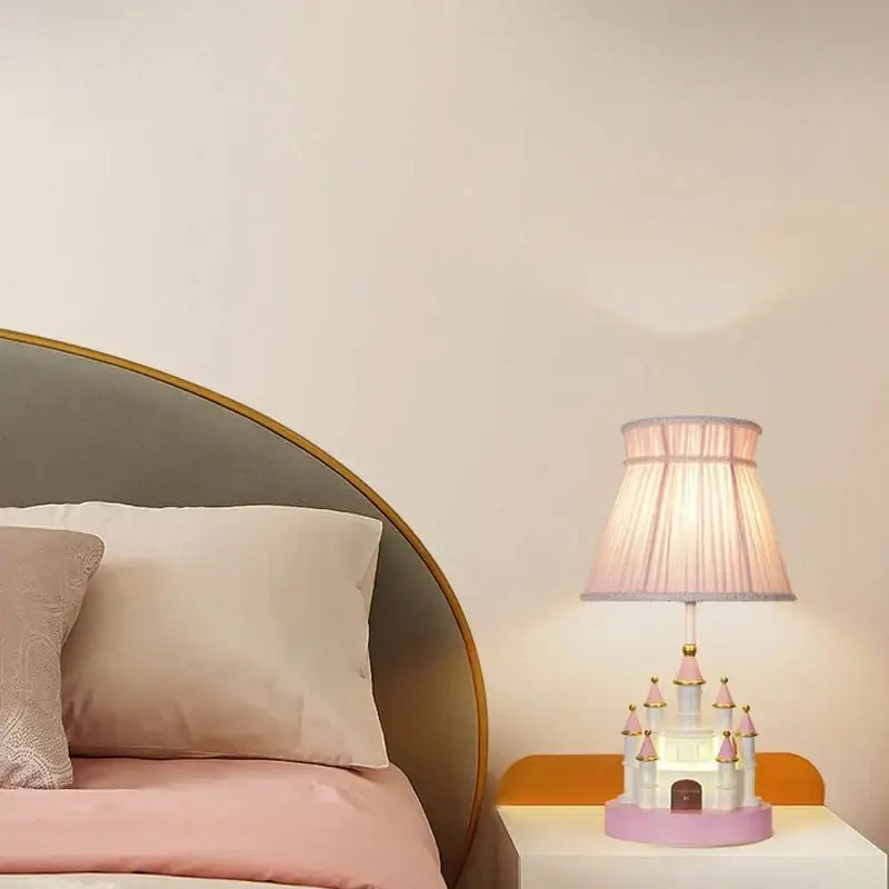 Delicate pink and white castle kids chandelier led table lamp with gold accents and pleated fabric shade by decorbites castle kids
