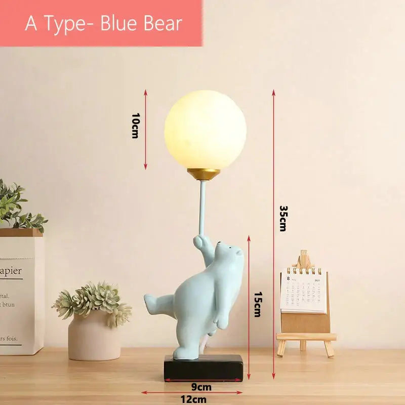 A charming light blue polar bear moon lamp figurine holding a glowing spherical lamp with gold accents
