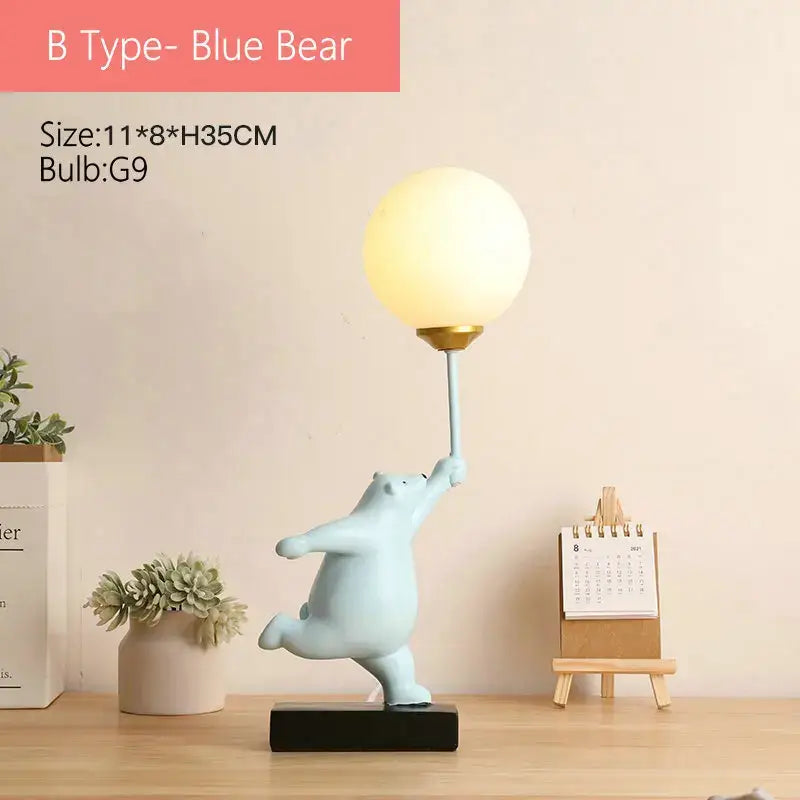 Light blue ceramic bear moon lamp holding a spherical frosted glass lampshade with gold accents for bedroom use