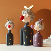 Three whimsical bubble girl resin figurines with gray curly hair and polka dot outfits for living room decor