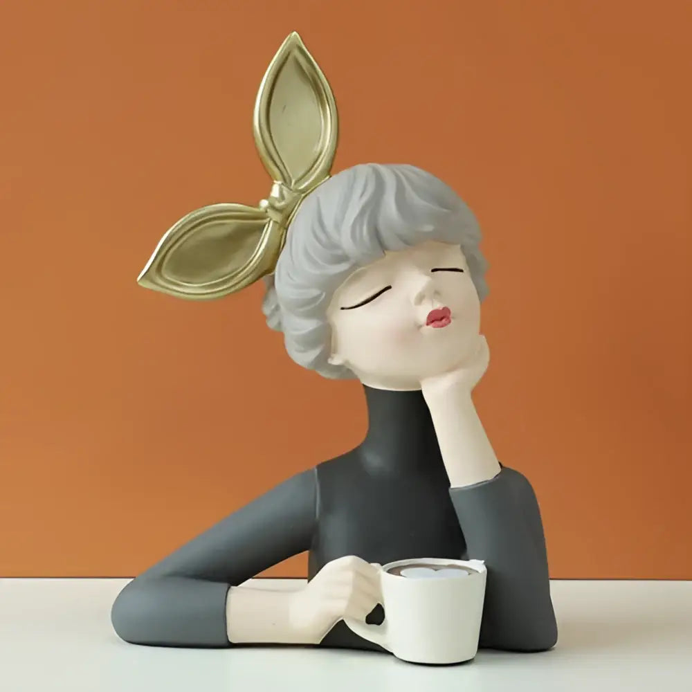 Gray resin bubble girl figurine with short hair, black turtleneck, white mug, and gold leaf accessory for living room decor