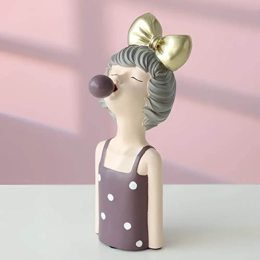 A whimsical bubble girl resin figurine with gray hair, gold bow, and purple bubble gum for living room decor