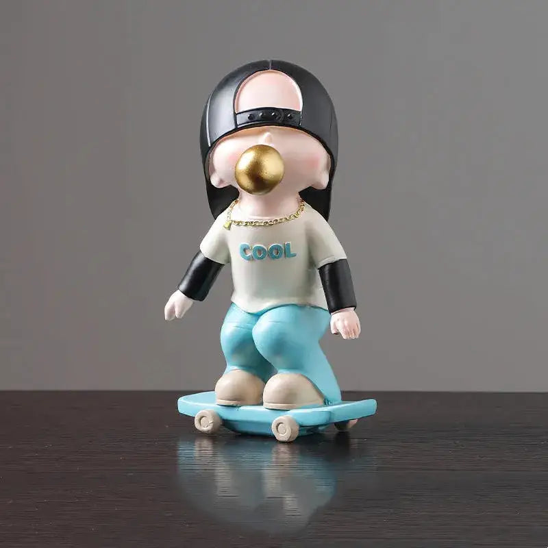 Whimsical resin boys sports statue of a cartoon boy in a black cap on a skateboard blowing a golden bubble for decorbites boys sports decor