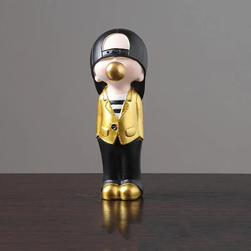 A glossy black and gold resin decorbites boys sports statue of a stylized person with a backward cap and golden shoes