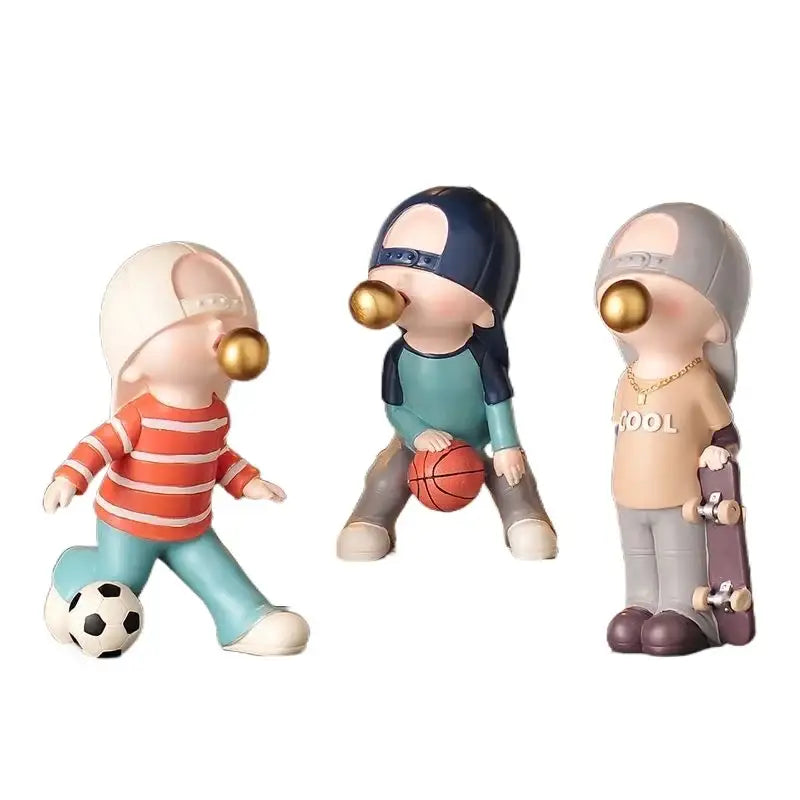 Set of three whimsical decorbites boys sports resin statues featuring kids in sporty outfits with gold bubblegum mouths