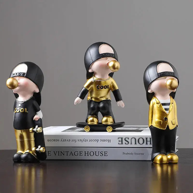 Three whimsical resin boys sports statues in black and gold outfits blowing golden bubblegum bubbles for decorbites boys decor