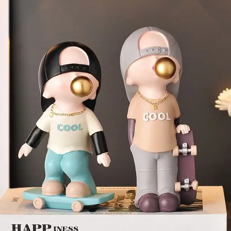 Two whimsical resin boys sports statues with skateboards in blue and purple for decorbites boys sports decor