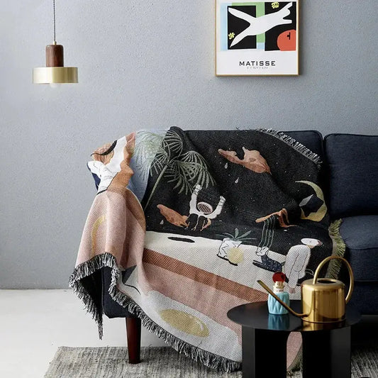 Black decorbites knit sofa blanket with whimsical space design featuring astronauts palm trees and celestial elements