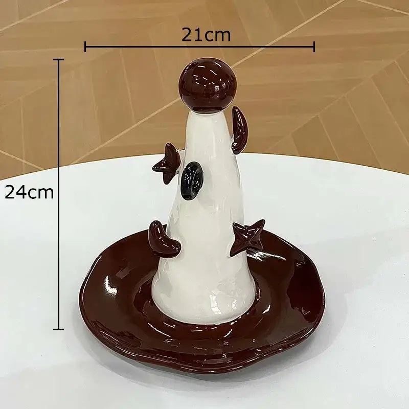 Glossy white and dark brown ceramic jewelry display stand with whimsical cone shape and star accents for bedroom decor
