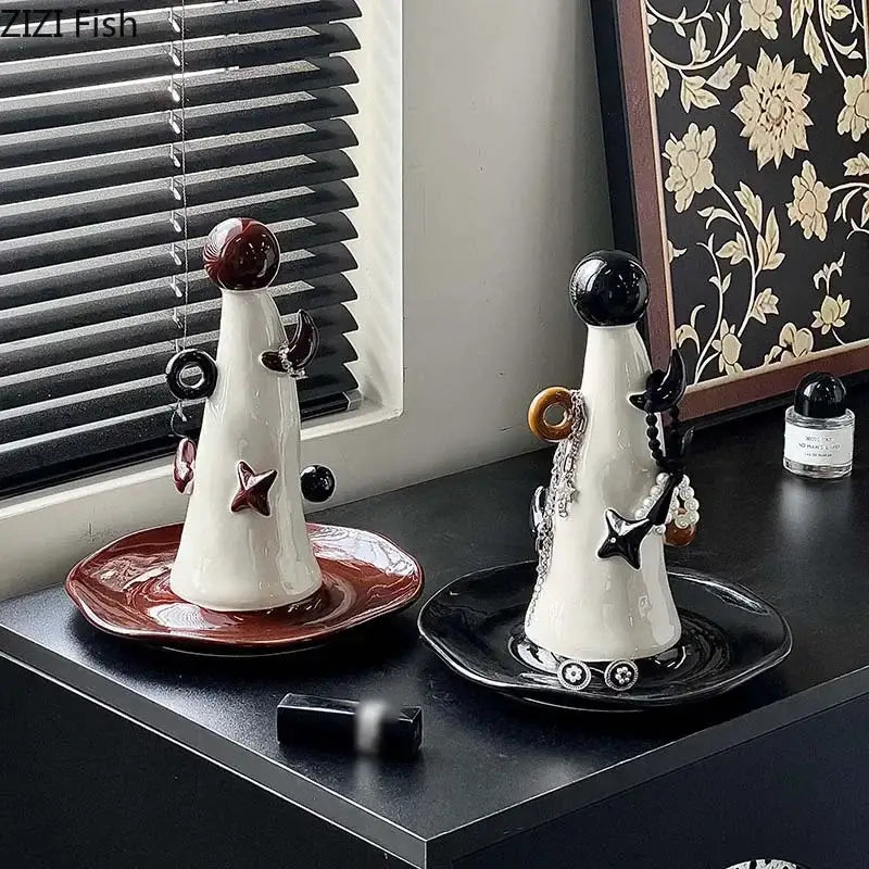 Whimsical white and brown ceramic jewelry display stand with glossy black and maroon tops and dangling charm accents