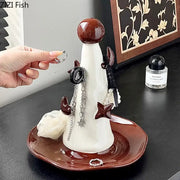 Whimsical white and brown ceramic jewelry display stand with glossy spherical top and decorative horns and pearl accents
