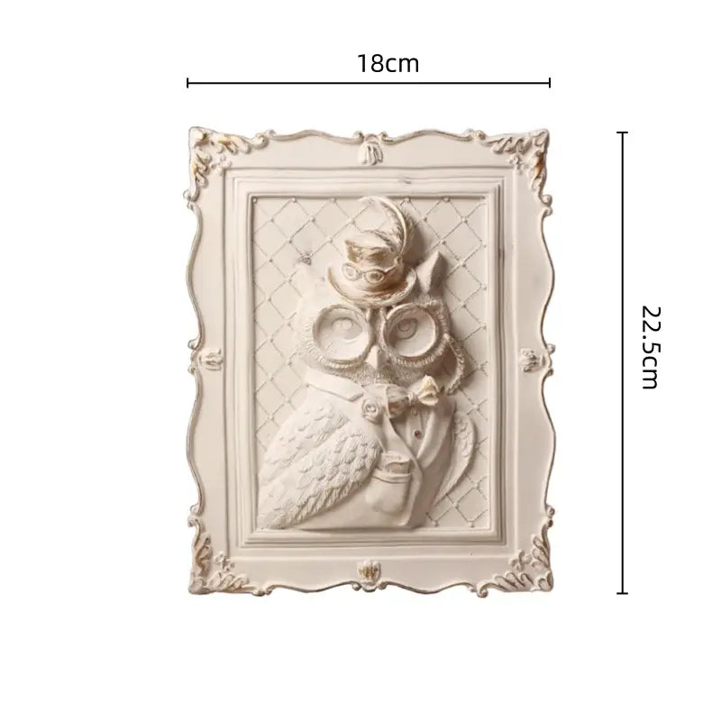 Ornate off-white owl sculpture with top hat in a decorative wall decoration frame for bedroom use