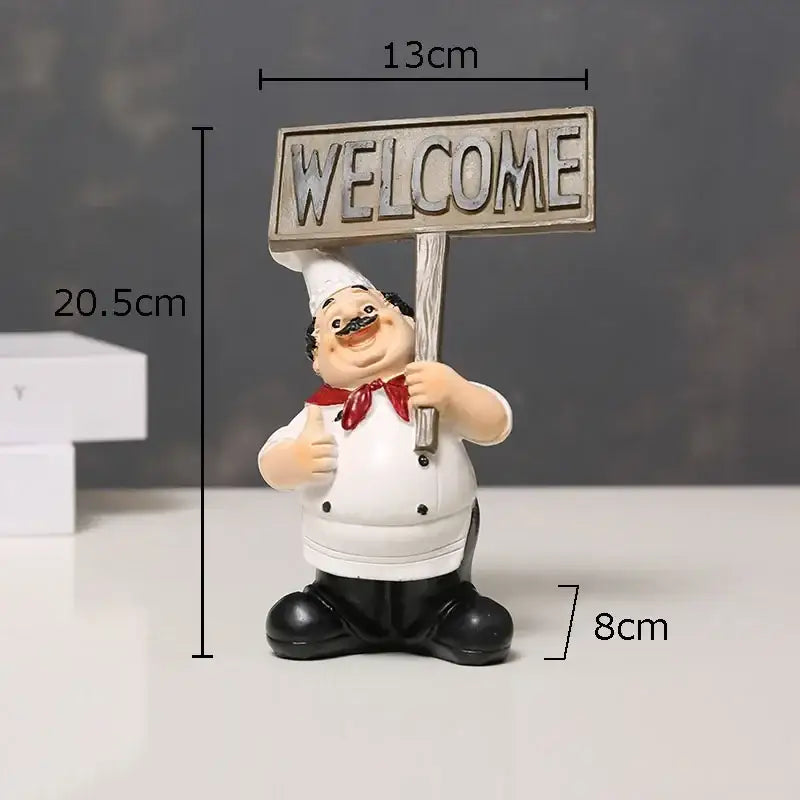 A cheerful white bearded chef resin figure with red bow tie holding a weathered wooden welcome sign for kitchen decor