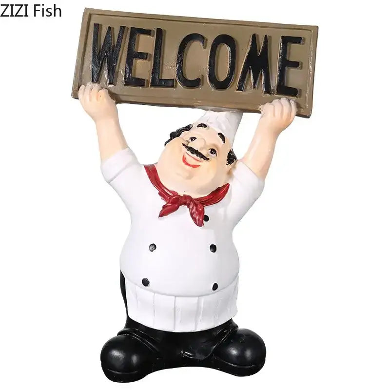 A cheerful whimsical white bearded chef resin figure in a white coat holding a tan welcome sign for kitchen decor