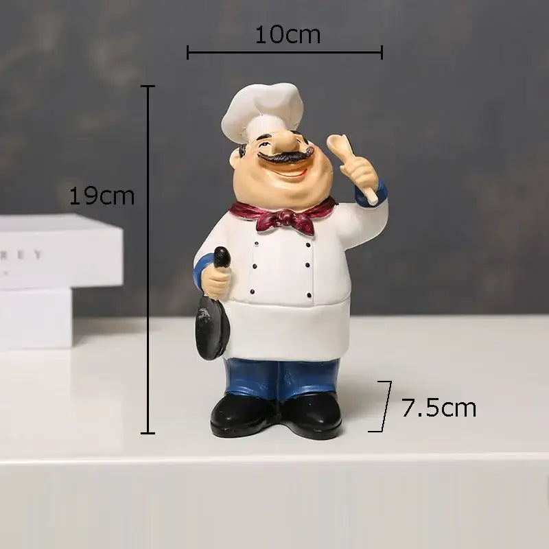 A cheerful white bearded chef resin figure with white coat blue pants and red bow tie for kitchen decor