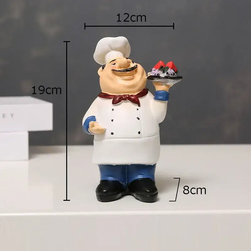 A cheerful bearded chef resin figure with white hat red bow tie and blue pants holding a dessert tray for kitchen decor