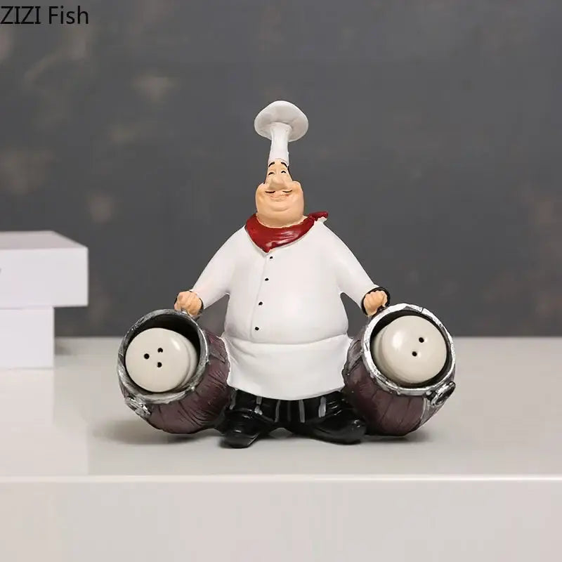 A whimsical bearded chef resin figure in white coat and toque holding barrel salt and pepper shakers for kitchen decor