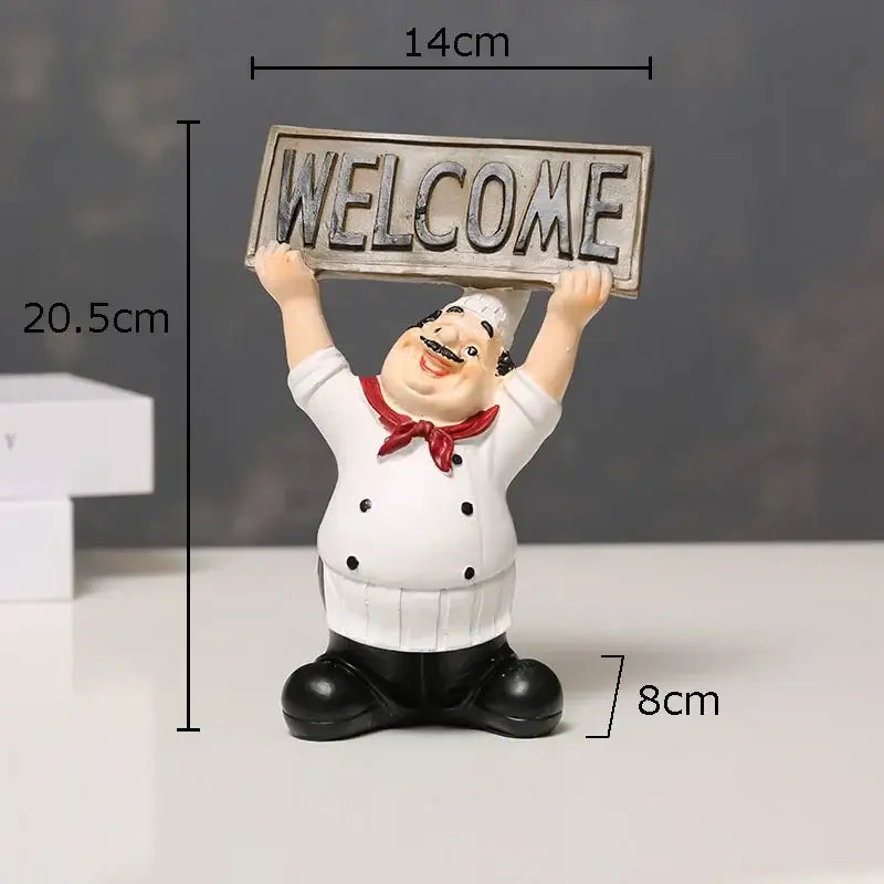A cheerful white bearded chef resin figure with black boots holding a weathered silver welcome sign for kitchen decor