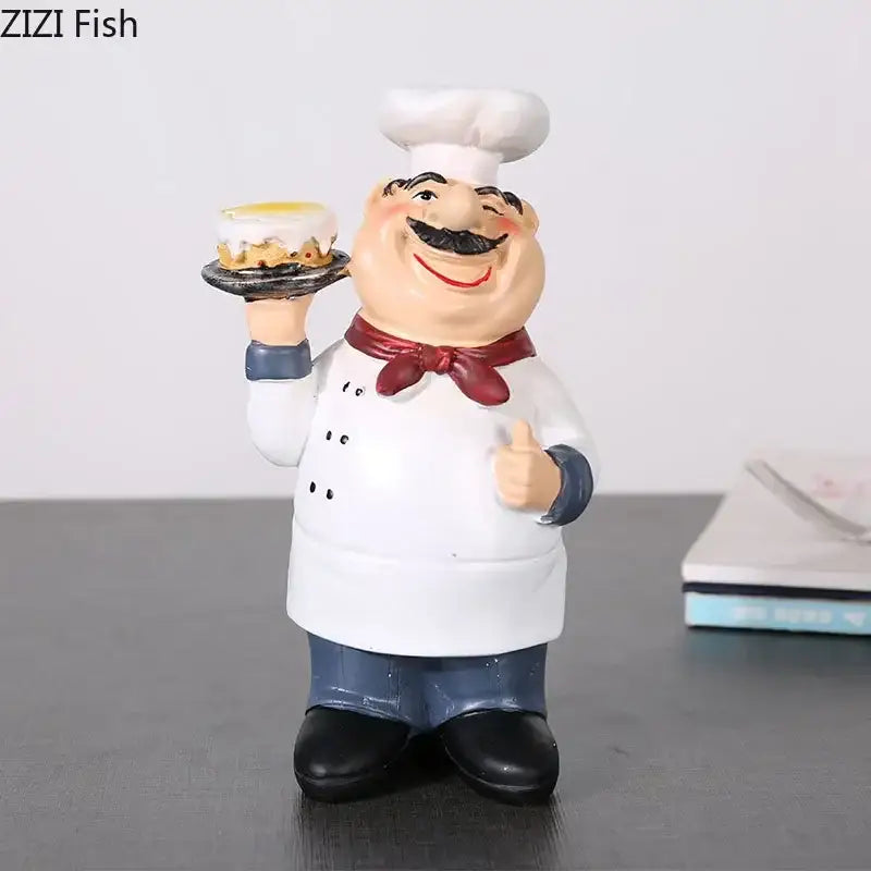 Whimsical white bearded chef resin figure with red bow tie and blue pants holding cake for kitchen decor