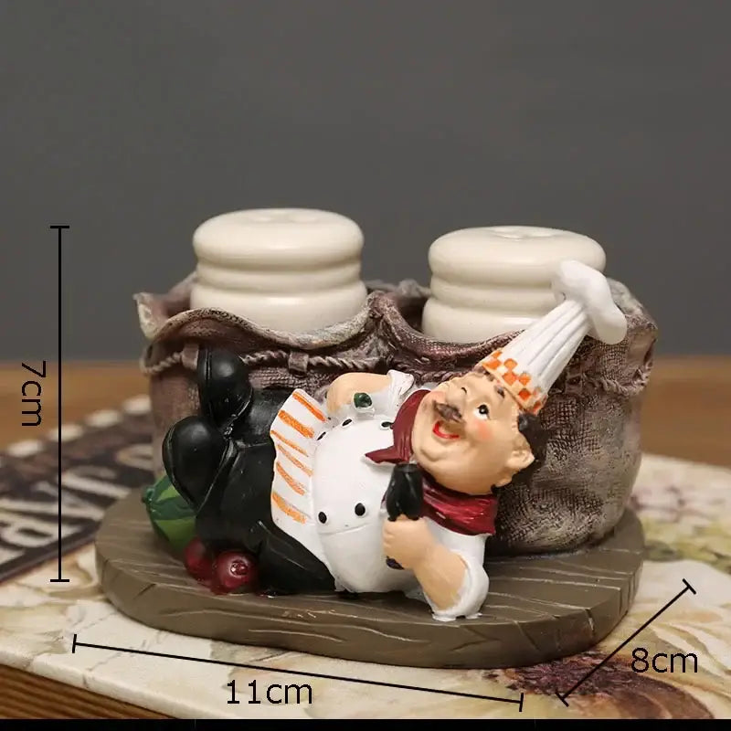 Whimsical white bearded chef resin figure in white coat reclining on wooden base with ceramic salt and pepper shakers