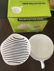 White and black easy salad cutter bowl with handle and parallel ridges designed for slicing vegetables easily