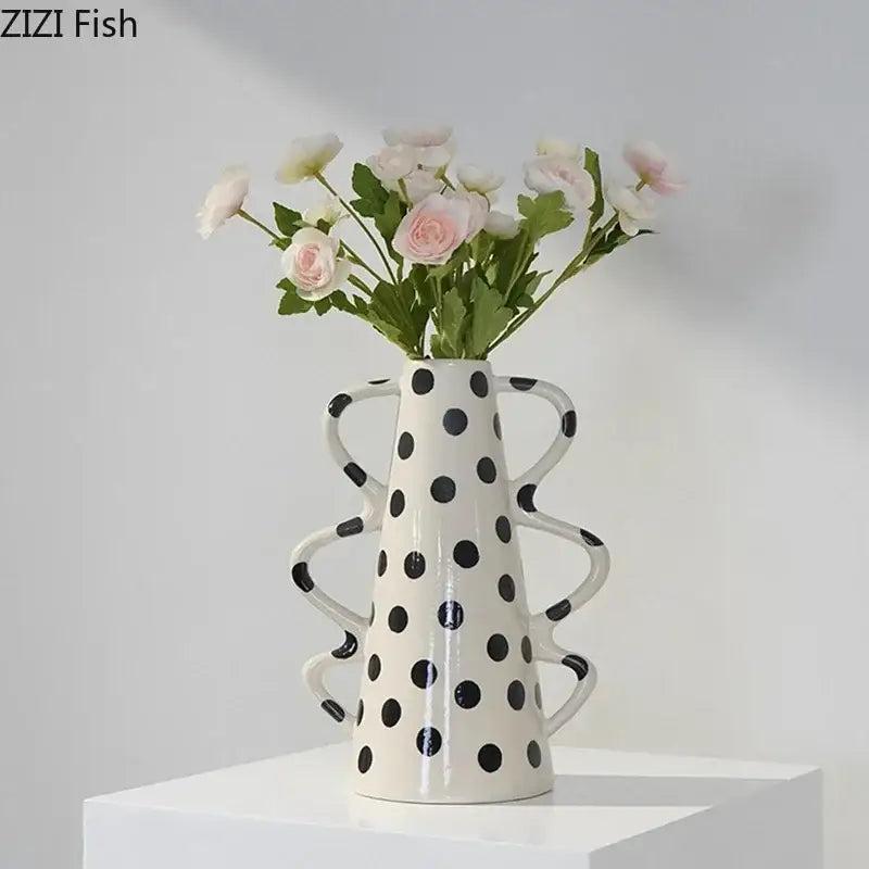 White ceramic vase with black polka dots and curved sculpted handles for living room decor