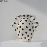 White ceramic vase with black polka dot pattern and wavy sculpted handles for living room decor