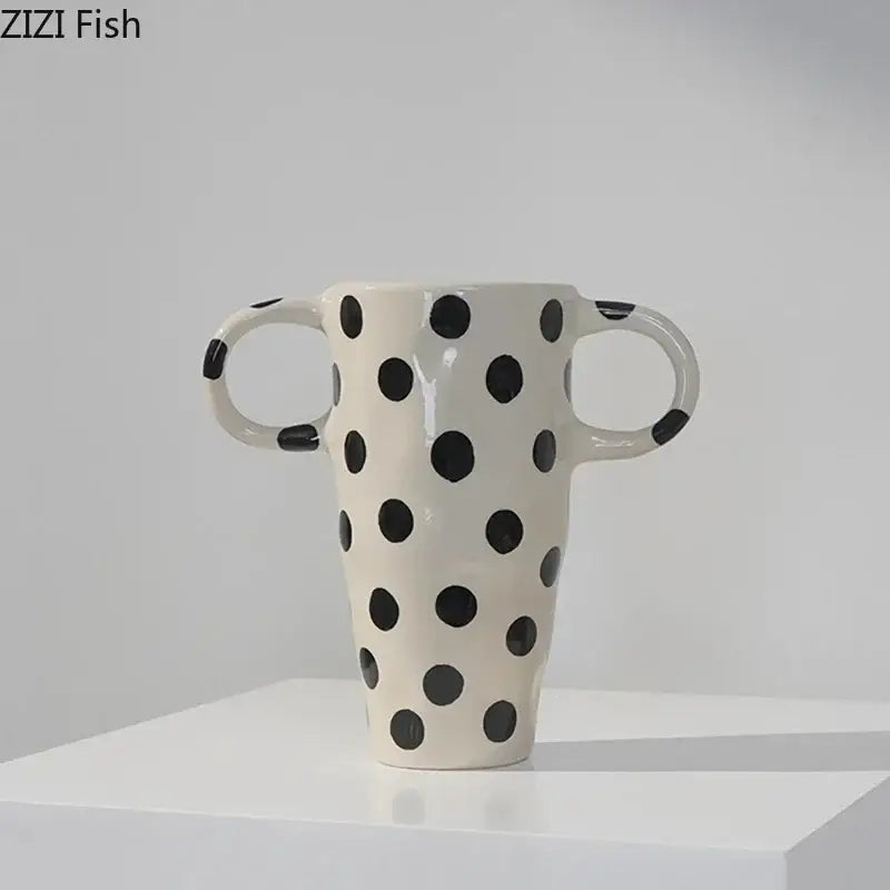 Cream-colored ceramic vase with black polka dot pattern and two looped handles for living room decor