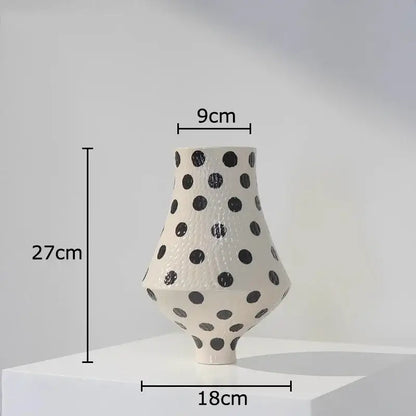 A sleek 27cm white ceramic vase with black polka dot texture and asymmetrical modern silhouette for living room decor