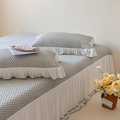 Gray quilted bed skirt with white ruffled trim and black piping in a decorbites cool feeling bedding set