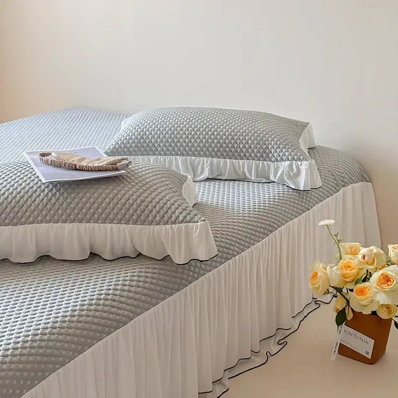 Gray quilted bed skirt with white ruffled trim and black piping in a decorbites cool feeling bedding set