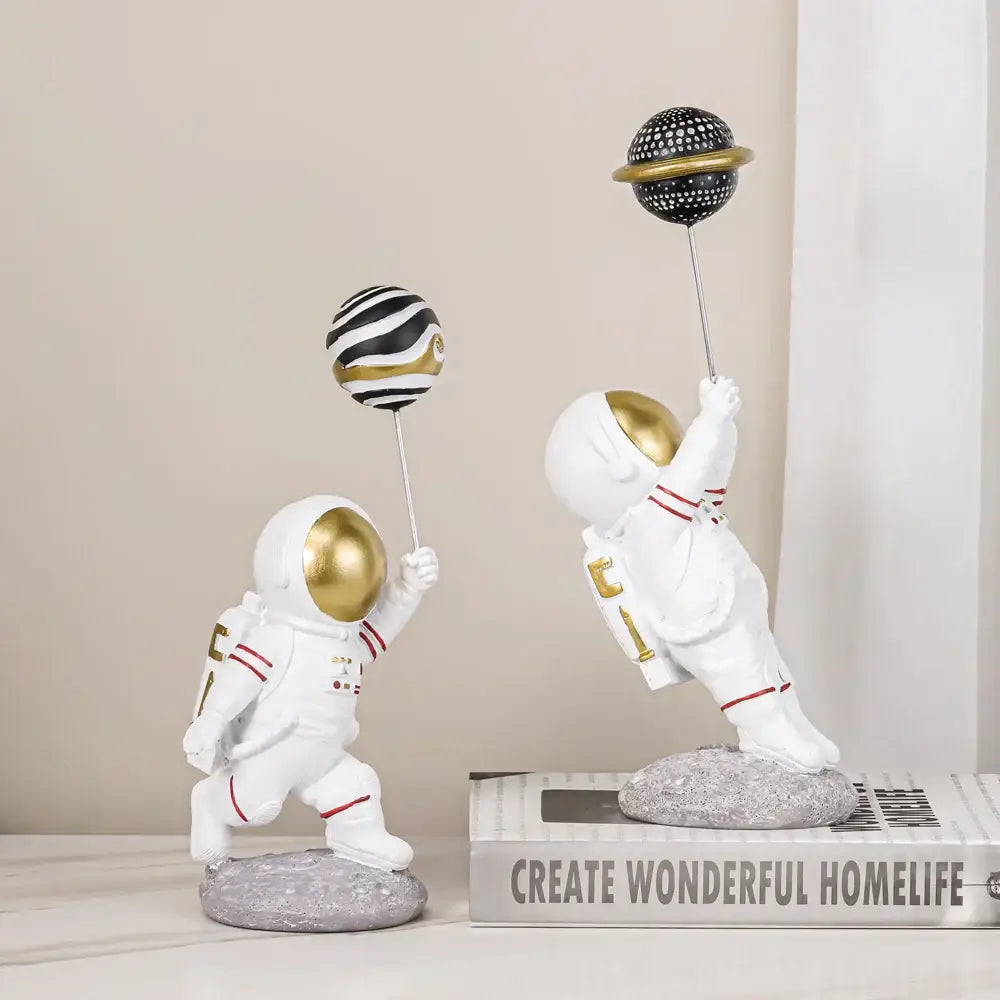 White and gold decorbites astronauts figurines with red detailing holding patterned planet balloons for living room decor