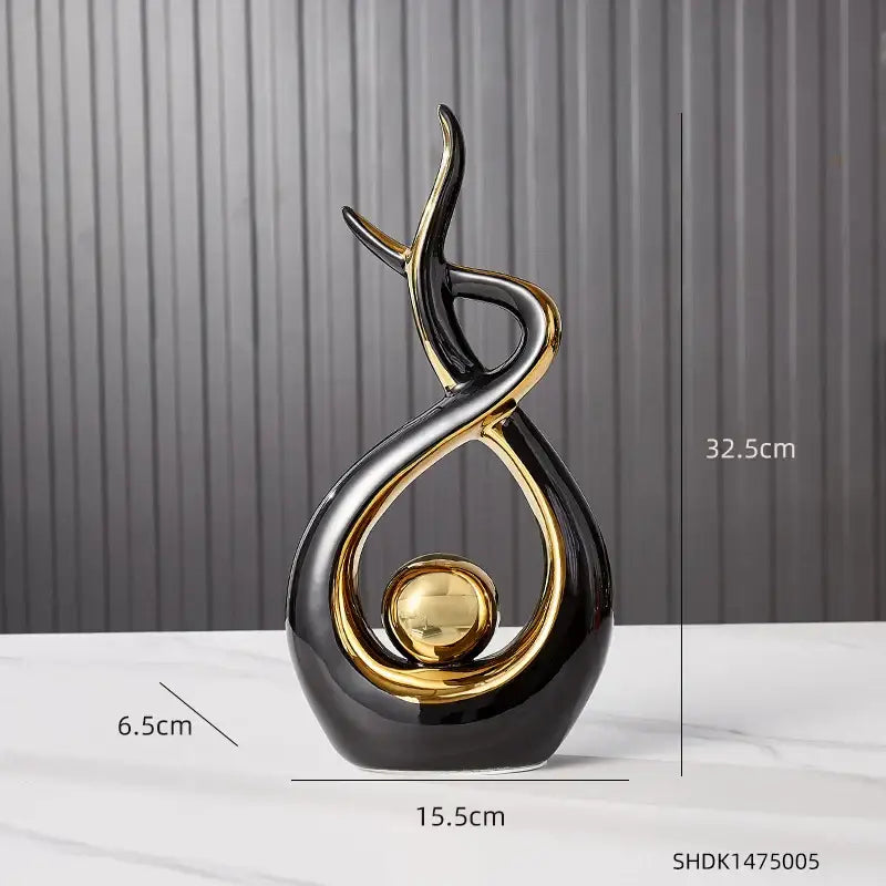 Elegant black and gold ceramic abstract figurine with flowing curves and a polished golden sphere for living room decorbites ceramic abstract