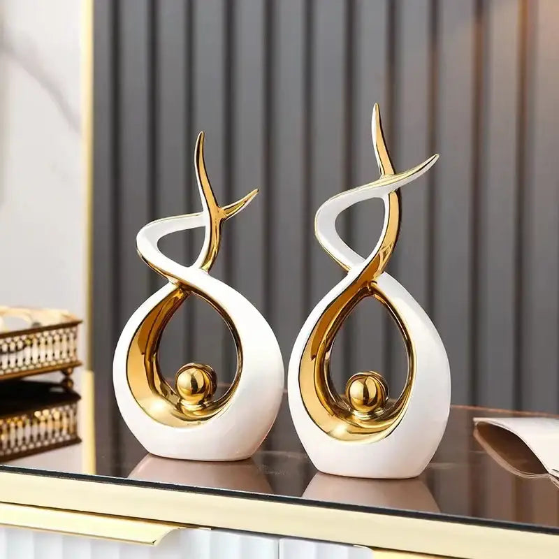 Two elegant white and gold ceramic abstract figurines with flowing designs for living room decorbites ceramic abstract set