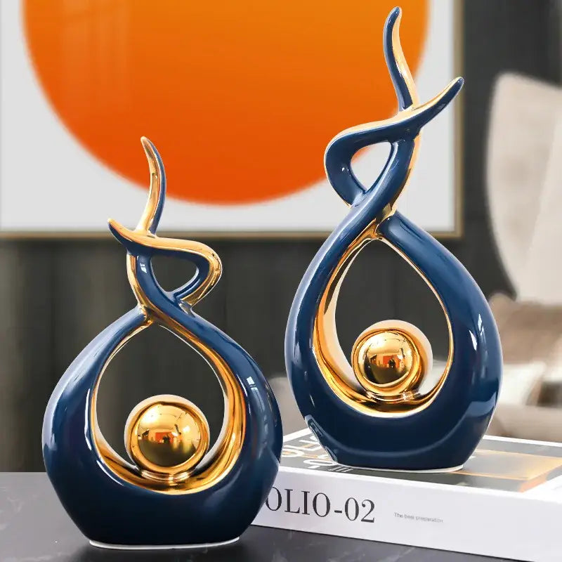 Two elegant navy blue ceramic abstract figurines with gold accents and reflective centers for decorbites ceramic abstract set