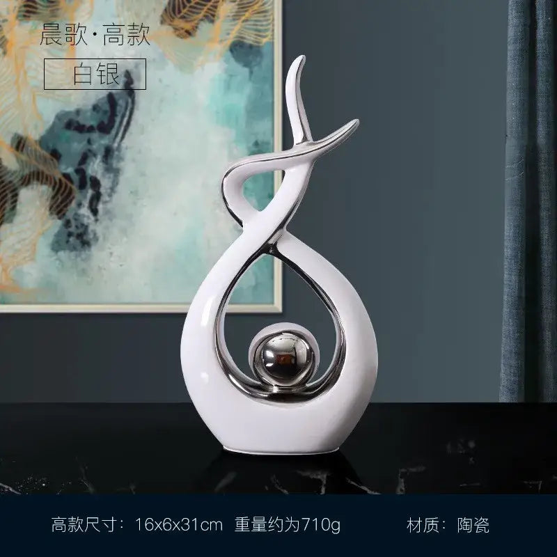 White and gold ceramic abstract figurine set featuring sleek white ceramic curves and a polished silver sphere for decorbites decor