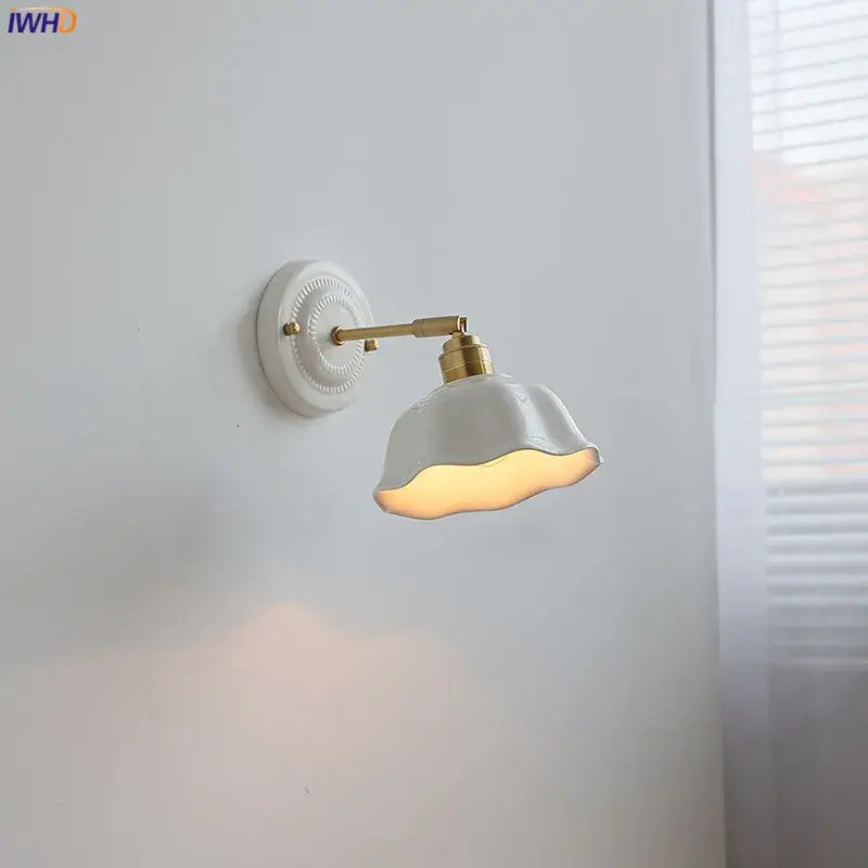 White and gold ceramic led wall light with gold-toned metal arm and decorative circular base decorbites ceramic led wall