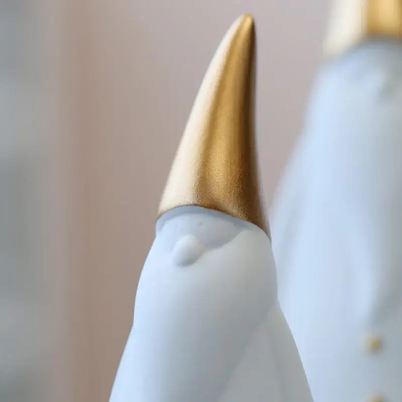 A sleek white ceramic swan figurine with polished gold beak for christmas living room santa claus figurines decor