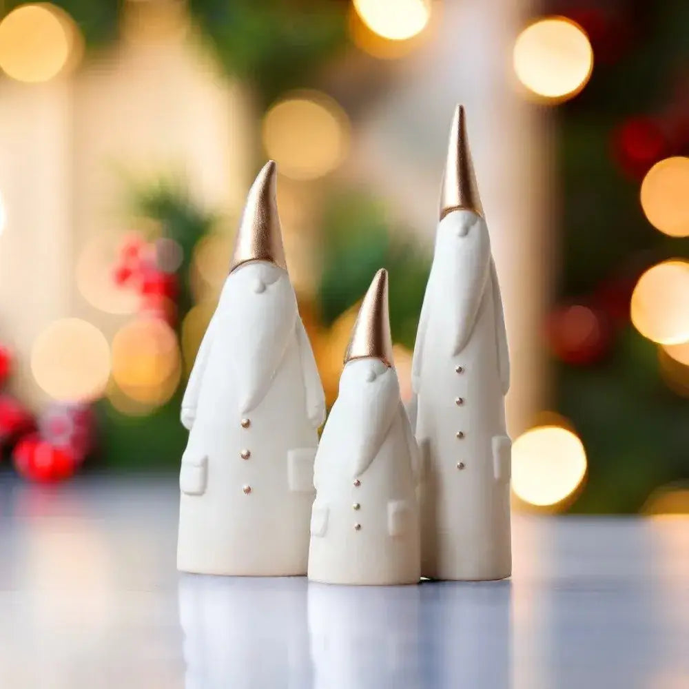 Three white and gold ceramic santa claus figurines with button details for christmas living room decor