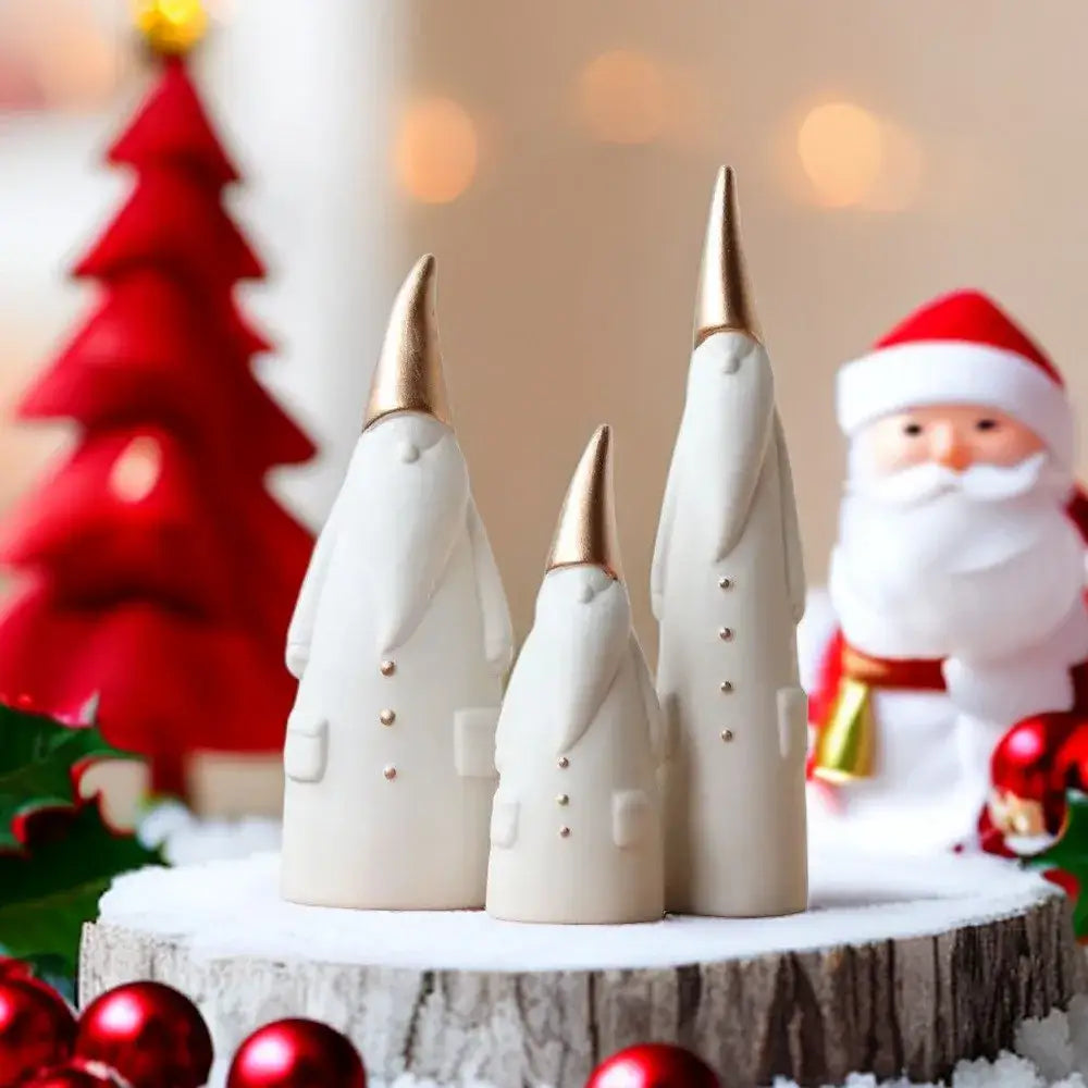 Three cream-colored ceramic santa claus figurines with gold-tipped hats and button details for christmas decor