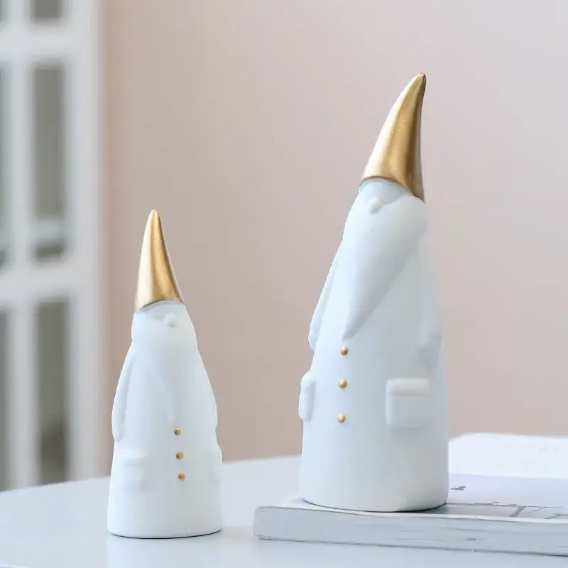 White and gold ceramic santa claus figurines with gold-tipped hats and button details for christmas decor