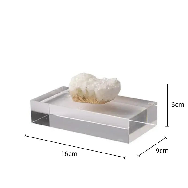 A clear acrylic display stand holding a white and gold crystal coralline ornament for living room decor