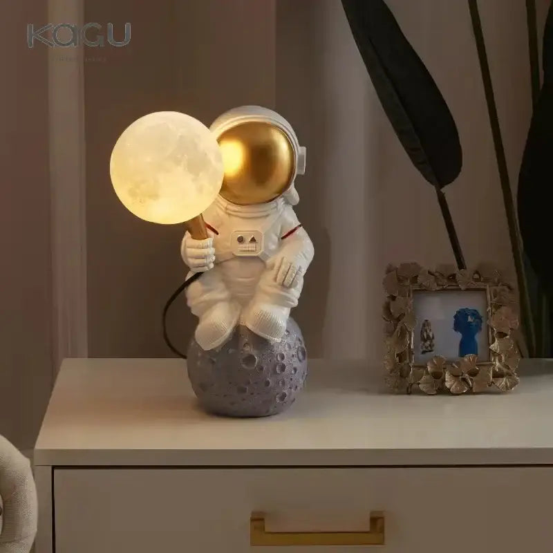 White and gold decorbites astronaut moon wall lamp with glowing lamp on gray moon planet table base for bedroom light
