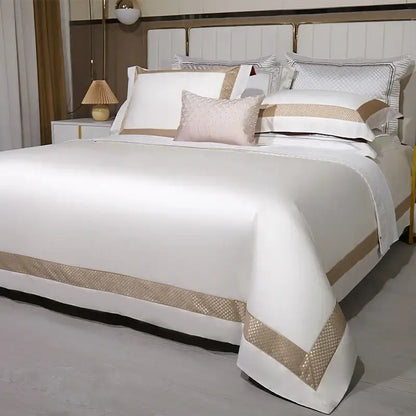 Elegant white satin egyptian cotton bedding set with gold embroidery and gold-toned woven trim and matching pillowcases