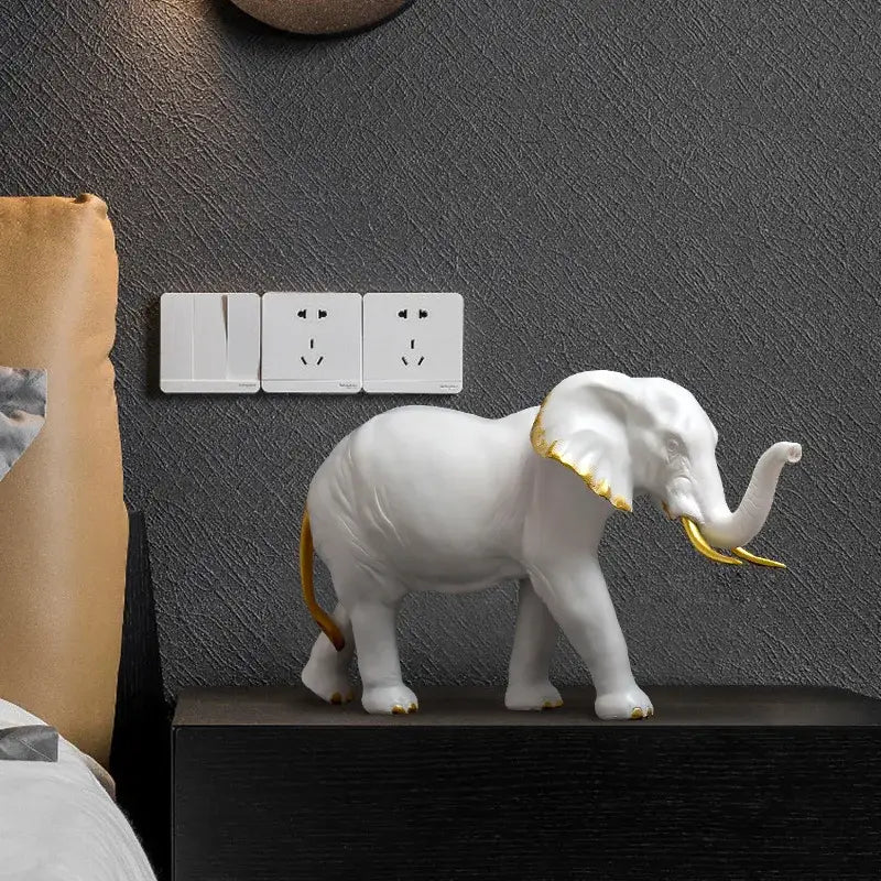 White and gold elephant resin sculpture ornament in ceramic with gold-trimmed ears tusks and tail for living room decor